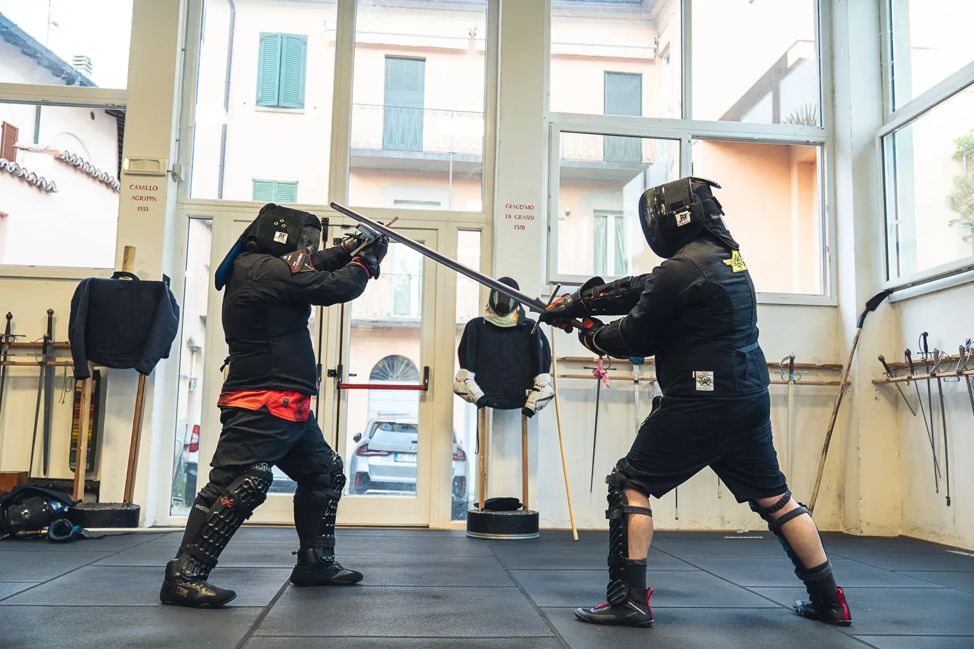 Due allievi di Sword Academy in guardia con la spada a due mani, la lama intera in evidenza